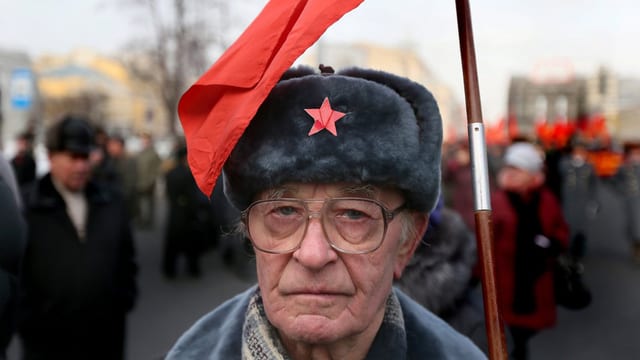 Ein KP-Mitglied an einer Kundgebung in Moskau