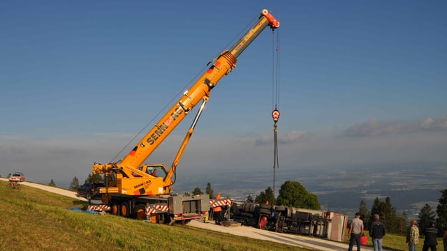 Ein Kran hebt einen Lastwagen an Ein Kran hebt einen Lastwagen an