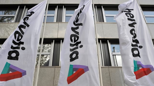 Flaggen mit Helvetia-Logo vor einem Gebäude. Flaggen mit Helvetia-Logo vor einem Gebäude.