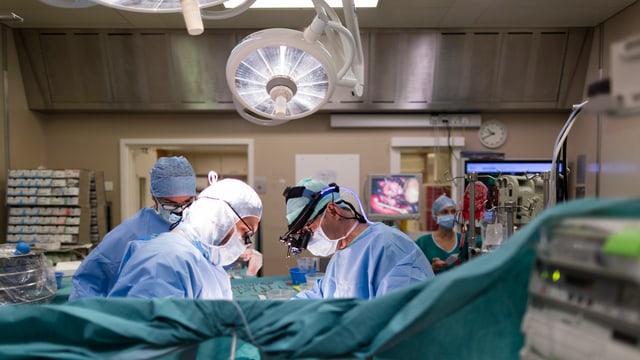 Operationssaal mit drei Ärzten Operationssaal mit drei Ärzten