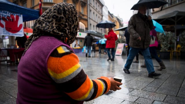 Ältere Frau auf kniend und bettelt um Geld Ältere Frau auf kniend und bettelt um Geld