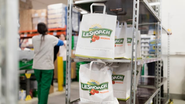 Einkaufstüten mit dem Le-Shop-Logo stehen in einem Regal. Einkaufstüten mit dem Le-Shop-Logo stehen in einem Regal.