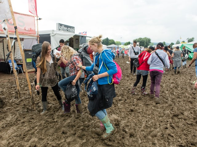 Diese Festivalbesucher zog der Schlamm schlicht die Gummistiefel aus - sie musste von ihren Kolleginnen gerettet werden.