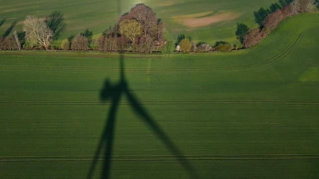 Der Schatten eines Windrads auf einer Wiese. Der Schatten eines Windrads auf einer Wiese.