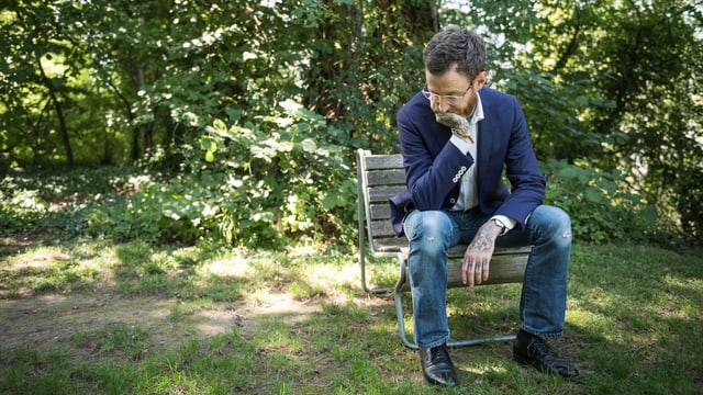 Autor Thomas Meyer in Denkerpose auf einem Holzstuhl. Autor Thomas Meyer in Denkerpose auf einem Holzstuhl.