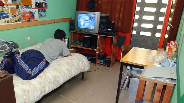 Jugendlicher im Zimmer auf Bett Jugendlicher im Zimmer auf Bett