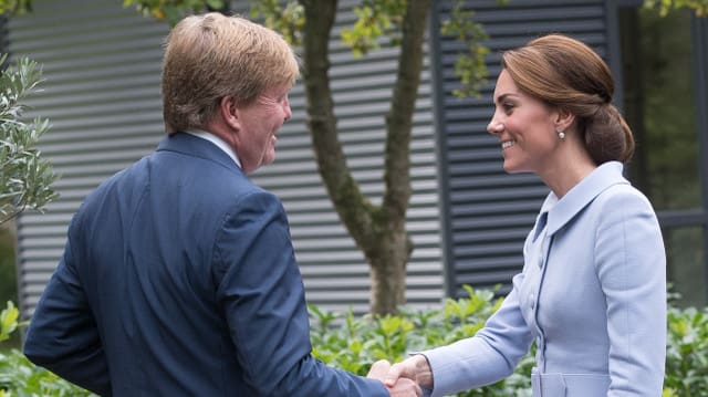 Herzogin Catherine und König Willelm Alexander schütteln sich die Hände. Herzogin Catherine und König Willelm Alexander schütteln sich die Hände.