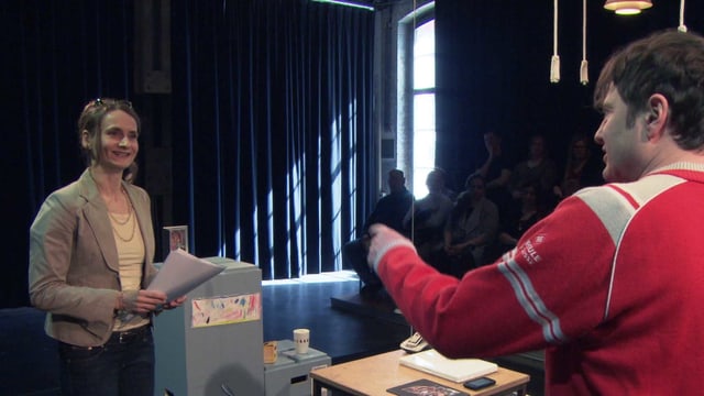 Auf der Theaterbühne: Ein Mann zeigt auf eine Frau. Auf der Theaterbühne: Ein Mann zeigt auf eine Frau.