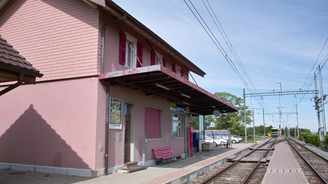 Bahnhofshäuschen mit Regionalzug im Hintergrund Bahnhofshäuschen mit Regionalzug im Hintergrund