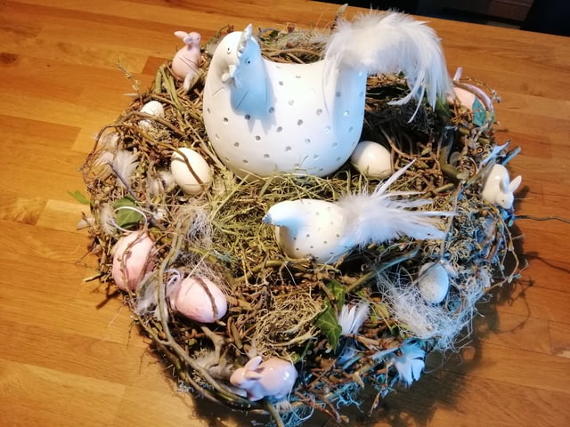 Osternest mit weissen Eiern und Hühnern.