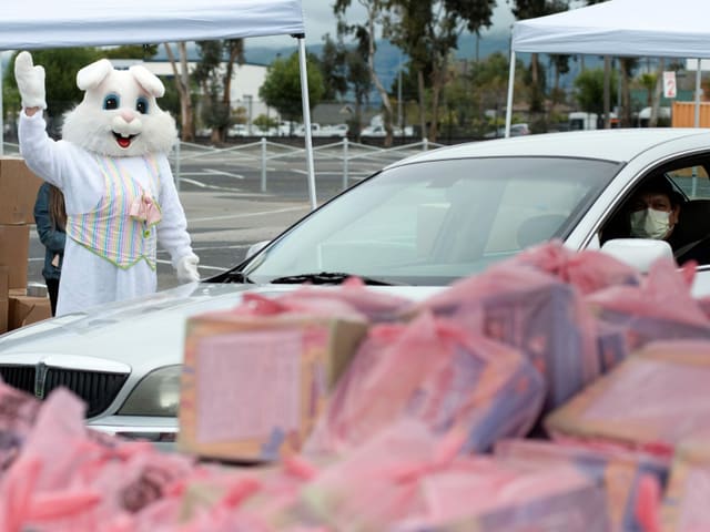 Osterhase winkt Auto zu