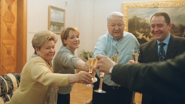 Eine Gruppe von Menschen, darunter Jelzin, stossen feierlich an mit einem Getränk. Eine Gruppe von Menschen, darunter Jelzin, stossen feierlich an mit einem Getränk.