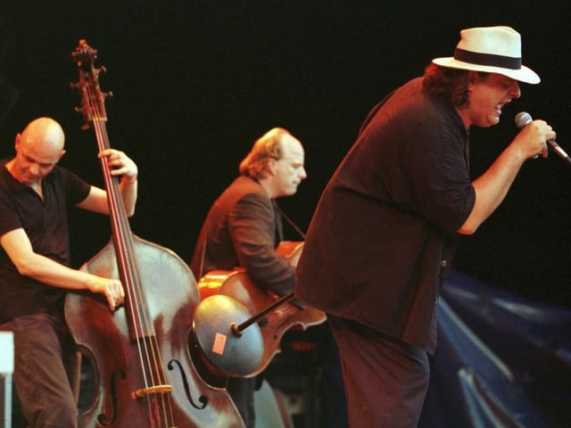 Drei Männer, die Musik spielen, auf einer Bühne