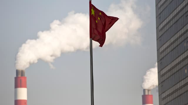 Die chinesische Flage im Vorderrgund, im Hintergrund qualmende Schornsteine. Die chinesische Flage im Vorderrgund, im Hintergrund qualmende Schornsteine.