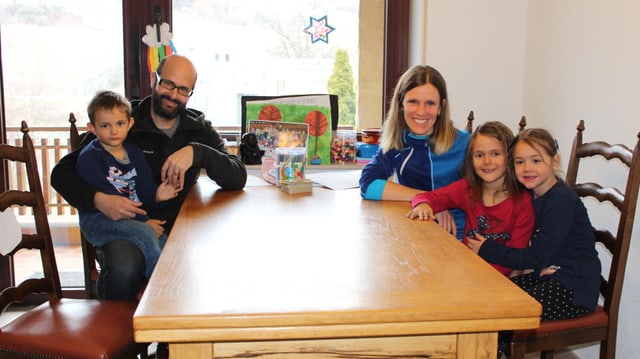 Eine Familie sitzt um den Tisch. Eine Familie sitzt um den Tisch.