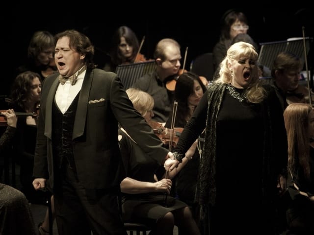 Zwei Opernsänger vor einem Orchester. Zwei Opernsänger vor einem Orchester.