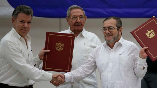 Der kolumbianische Präsident Juan Manuel Santos und der Farc-Chef Timoleon Jimenez präsentieren den Friedensvertrag. Der kolumbianische Präsident Juan Manuel Santos und der Farc-Chef Timoleon Jimenez präsentieren den Friedensvertrag.