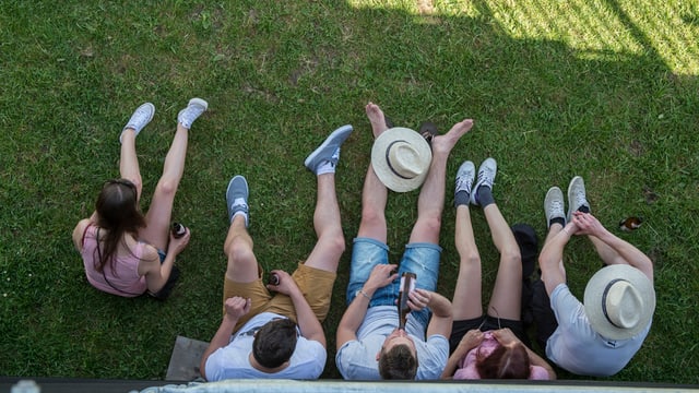 Jugendliche sitzen auf Wiese Jugendliche sitzen auf Wiese