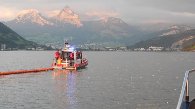Polizeiboot legt Ölsperre aus. Polizeiboot legt Ölsperre aus.