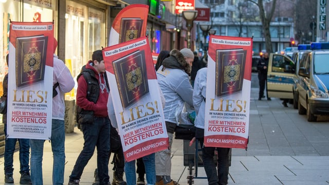 Eine Gruppe Männer. Auf dem Rücken Banner mir der Aufschrift Lies! Eine Gruppe Männer. Auf dem Rücken Banner mir der Aufschrift Lies!