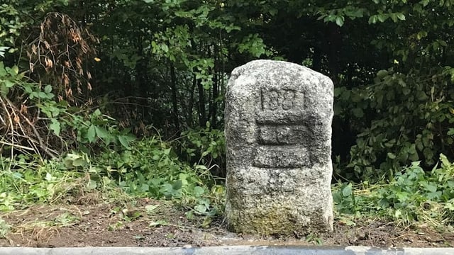 Der Grenzstein mit dem eingemeisselten Zuger Wappen. Der Grenzstein mit dem eingemeisselten Zuger Wappen.