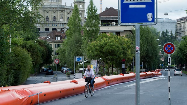 Ein oranger Schlauch neben einer Strasse, im Hintergrund das Bundeshaus. Ein oranger Schlauch neben einer Strasse, im Hintergrund das Bundeshaus.