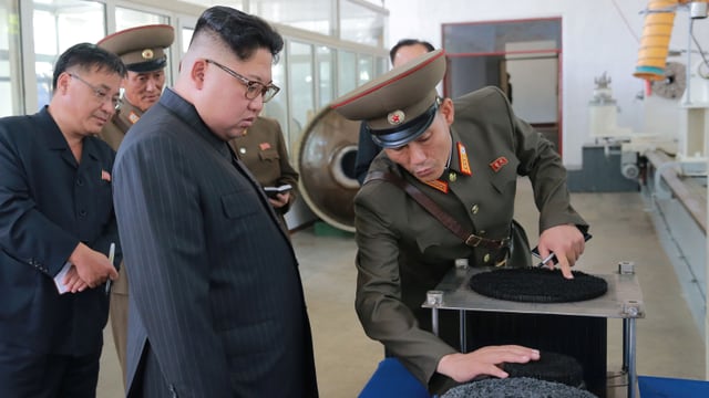 Kim lässt sich von einem uniformierten Militär etwas vorführen. Kim lässt sich von einem uniformierten Militär etwas vorführen.