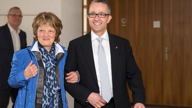 Weber lacht, seine Ehefrau hält ihn am Arm und lächelt. Weber lacht, seine Ehefrau hält ihn am Arm und lächelt.