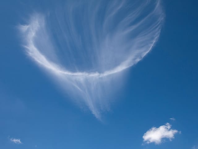 Quellenförmige Wolke am blauen Himmel
