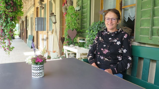 Eine Frau sitzt an einem Tisch. Eine Frau sitzt an einem Tisch.