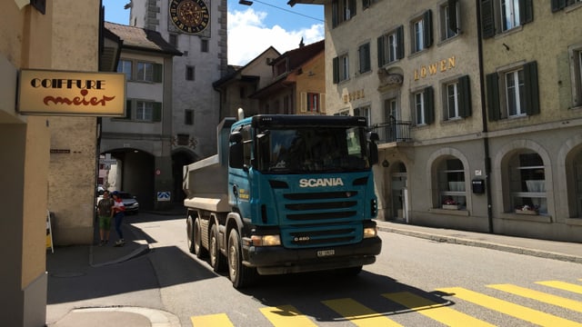 Ein Lastwagen fährt durch eine Innenstadt. Ein Lastwagen fährt durch eine Innenstadt.