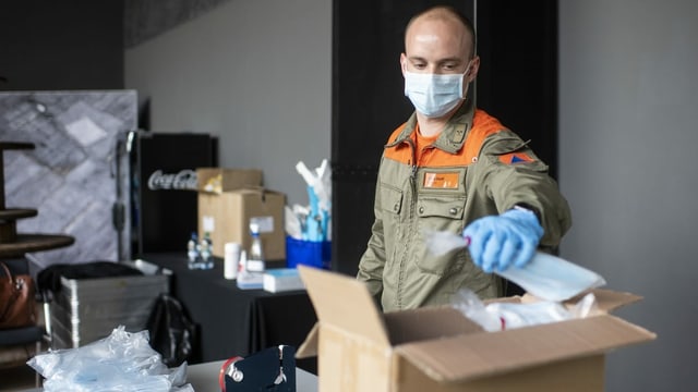 Mann vom Zivilschutz bei der Masken-Ausgabe.