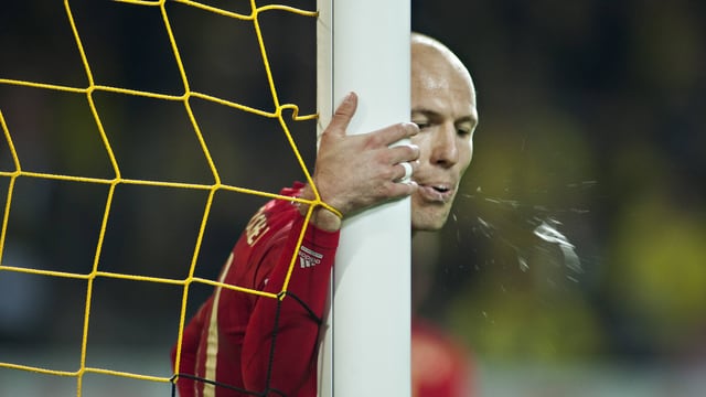 Arjen Robben vom FC Bayern München hält sich nach einem verschossenen Elfmeter kurz vor Spielschluss am Torpfosten fest und spuckt aufs Feld. Arjen Robben vom FC Bayern München hält sich nach einem verschossenen Elfmeter kurz vor Spielschluss am Torpfosten fest und spuckt aufs Feld.