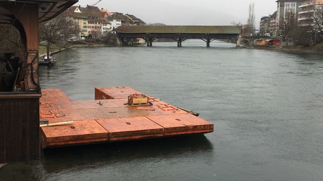 Orange Schwimmplattform hat ein wenig die Form eines U und liegt auf der Aare, befestigt durch Seile. Orange Schwimmplattform hat ein wenig die Form eines U und liegt auf der Aare, befestigt durch Seile.