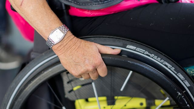 Frauenhand an Rollstuhlrad Frauenhand an Rollstuhlrad