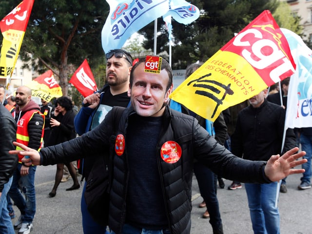 Ein Demonstrant mit Macron-Maske. Ein Demonstrant mit Macron-Maske.