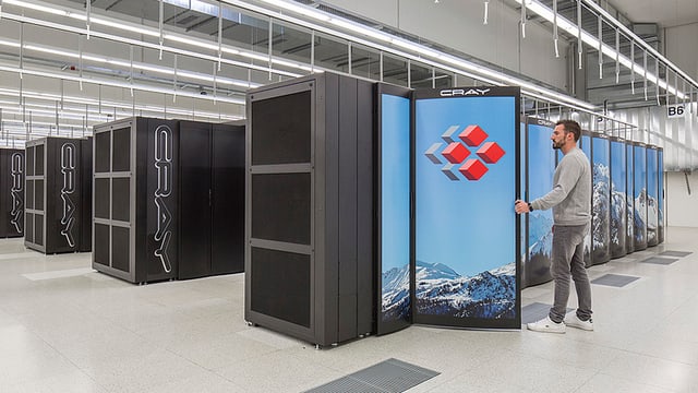 Schwarze Bleckkästen in einer Industriehalle, ein Mann hat einen von ihnen geöffnet. Schwarze Bleckkästen in einer Industriehalle, ein Mann hat einen von ihnen geöffnet.