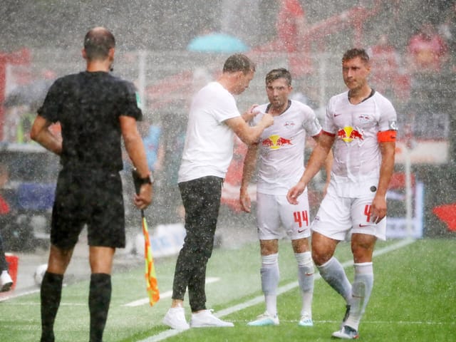 Leipzig-Coach Julian Nagelsmann spricht im Berliner Starkregen auf Kevin Kampl und Willi Orban ein.