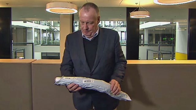 Mann betrachtet ein geknicktes Paket. Mann betrachtet ein geknicktes Paket.