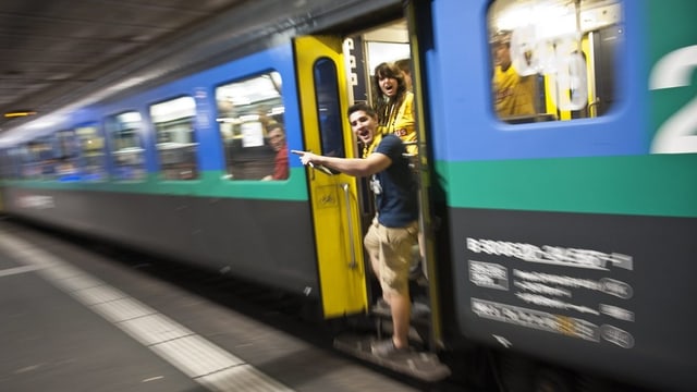 Fans stehen bei der Zugtüre. Fans stehen bei der Zugtüre.
