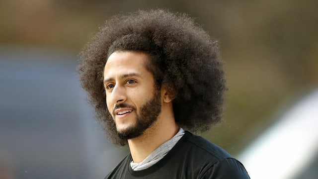 Mann mit krausem Haar und dunklem Bart schaut seitlich an der Kamera vorbei. Er trägt ein Sporttrikot. Mann mit krausem Haar und dunklem Bart schaut seitlich an der Kamera vorbei. Er trägt ein Sporttrikot.