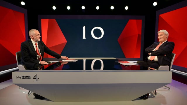 Corbyn ed in moderatur en in setting da televisiun. Corbyn ed in moderatur en in setting da televisiun.