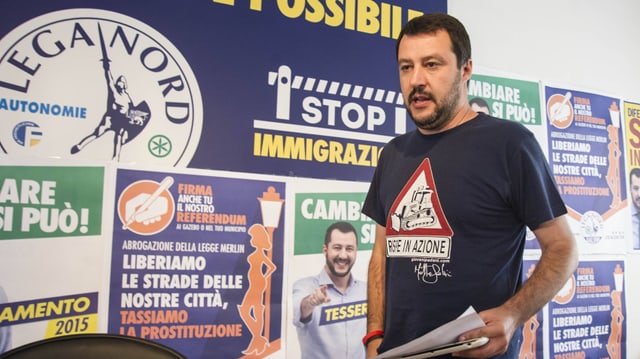 Salviini, ein Mann mit schwarzem Bart, steht vor Wahlplakaten seiner Partei. Salviini, ein Mann mit schwarzem Bart, steht vor Wahlplakaten seiner Partei.