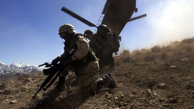 Zwei US-Soldaten vor einem Helikopter Zwei US-Soldaten vor einem Helikopter