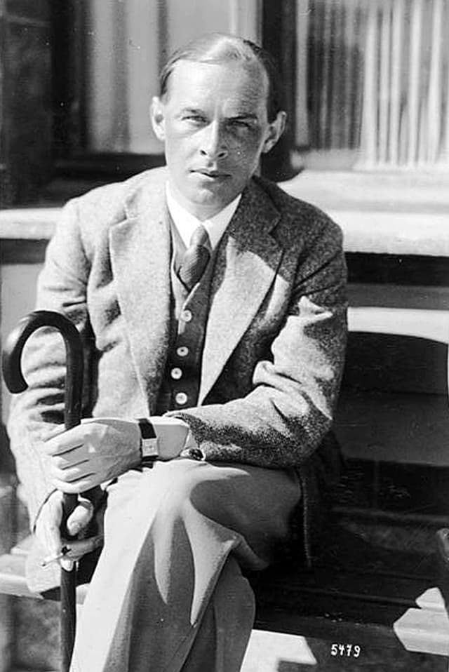 Erich Maria Remarque sitzt auf einer Bank in der Sonne, elegant gekleidet in Anzug und mit Schirm. Erich Maria Remarque sitzt auf einer Bank in der Sonne, elegant gekleidet in Anzug und mit Schirm.
