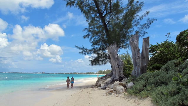 Zwei Frauen spazieren am Strand der Cayman Islands. Zwei Frauen spazieren am Strand der Cayman Islands.
