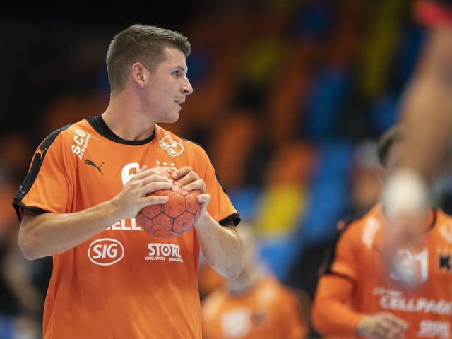 Dimitrij Küttel im Trikot der Kadetten hat einen Ball in der Hand. Dimitrij Küttel im Trikot der Kadetten hat einen Ball in der Hand.