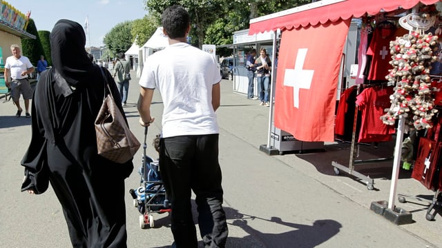 Eine verschleierte Frau und ihr Mann in den Strassen von Genf Eine verschleierte Frau und ihr Mann in den Strassen von Genf