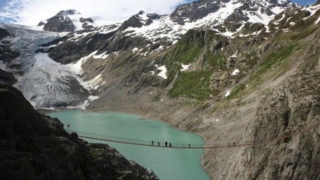 Gletscher und -see, umrahmt von Bergen, eine Hängebrücke führt über den See. Gletscher und -see, umrahmt von Bergen, eine Hängebrücke führt über den See.