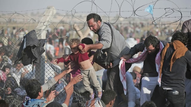 Syrische Flüchtlinge klettern 2015 über den Grenzzaun die Türkei Syrische Flüchtlinge klettern 2015 über den Grenzzaun die Türkei